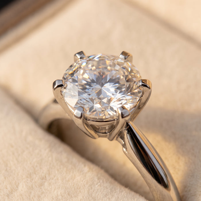 Macro of a six-prong silver setting holding a brilliant-cut moissanite