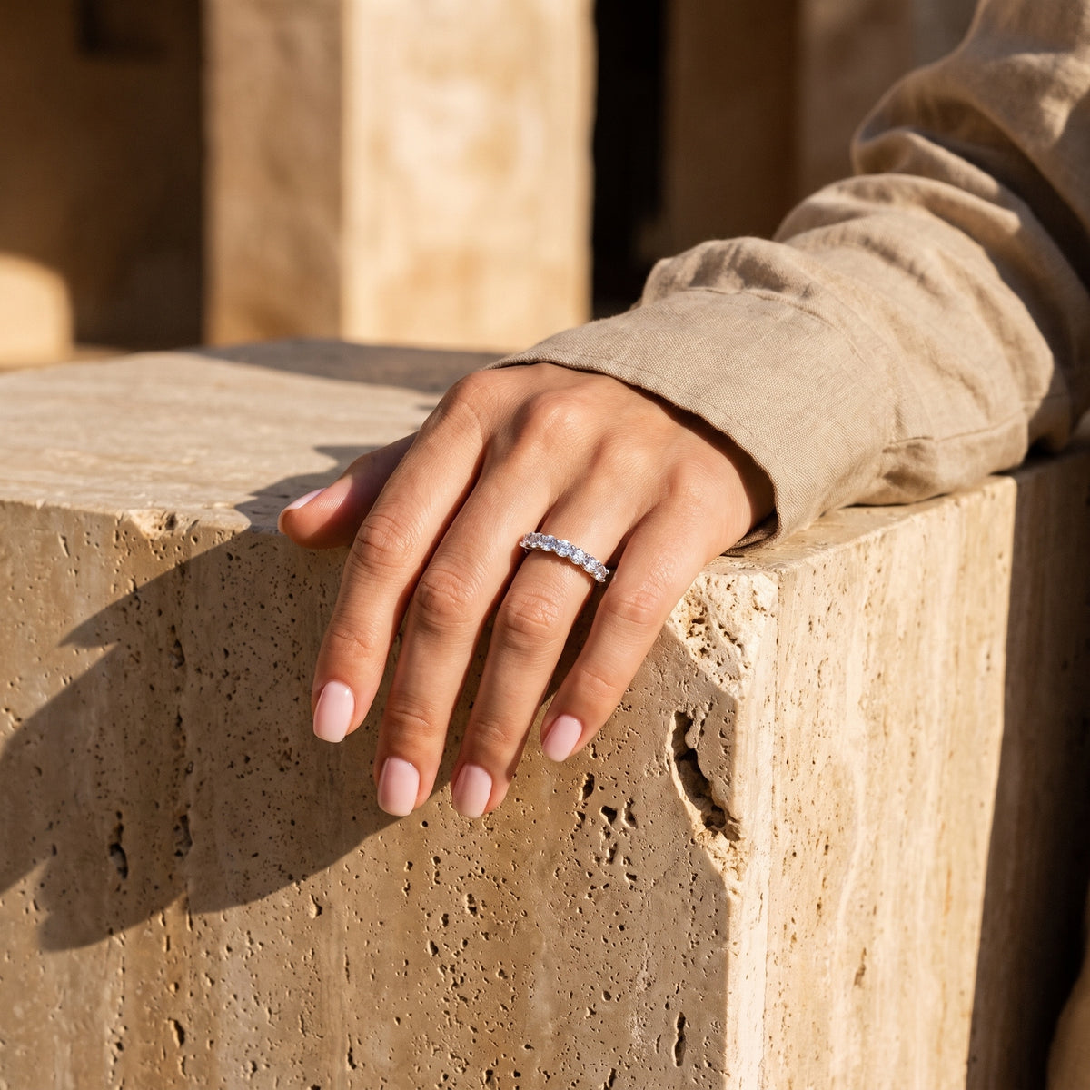 Sette Ring worn on hand on a travertine block in sunlight