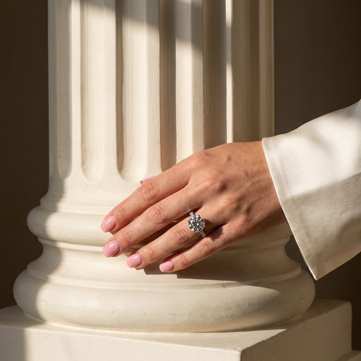 Aurora Ring worn on hand against a fluted plaster column