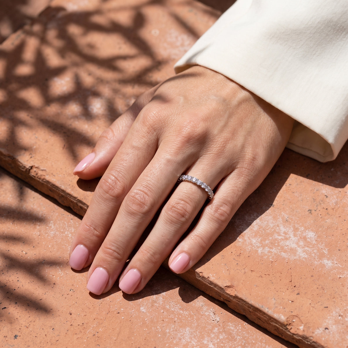 Infinita Half Band Ring worn on hand on terracotta in dappled sunlight