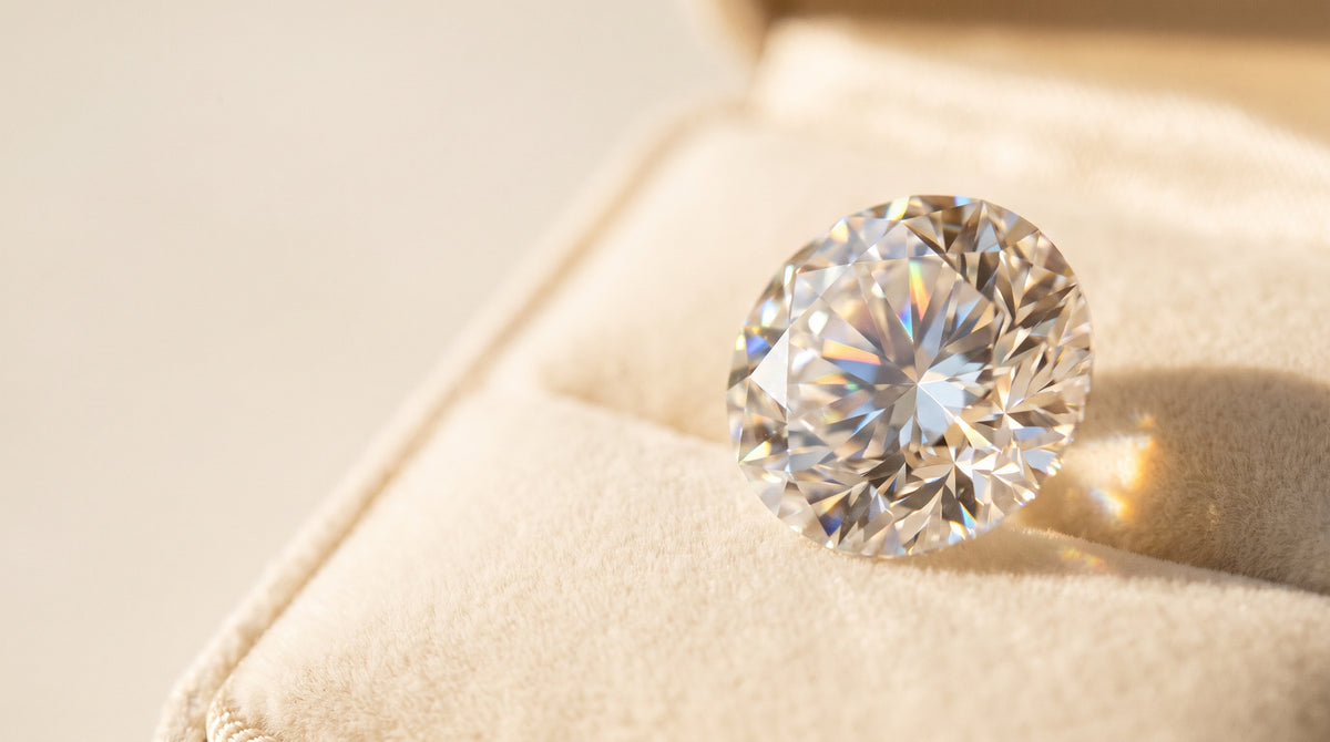 Macro close-up of a brilliant-cut moissanite stone on cream velvet
